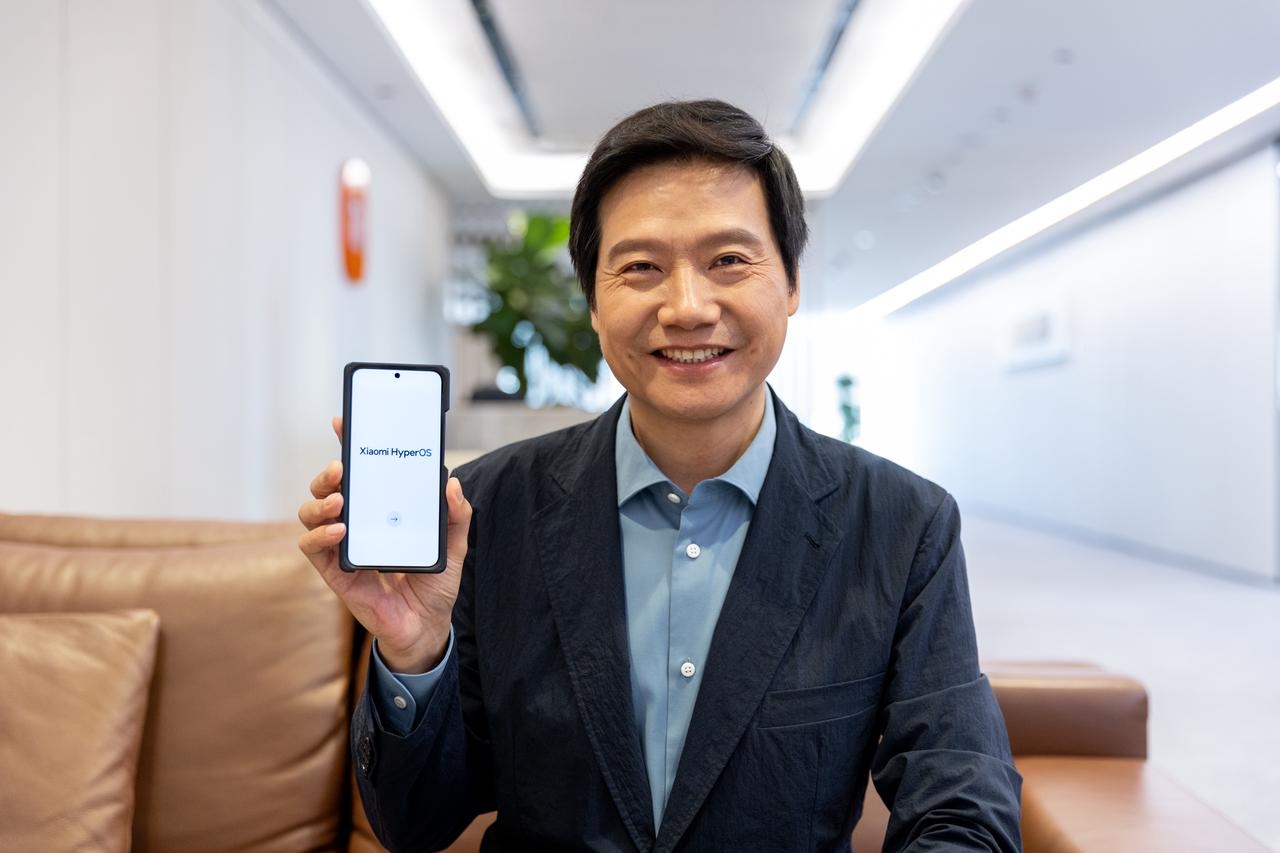 Der Xiaomi-Gründer Lei Jun mit einem Smartphone mit HyperOS